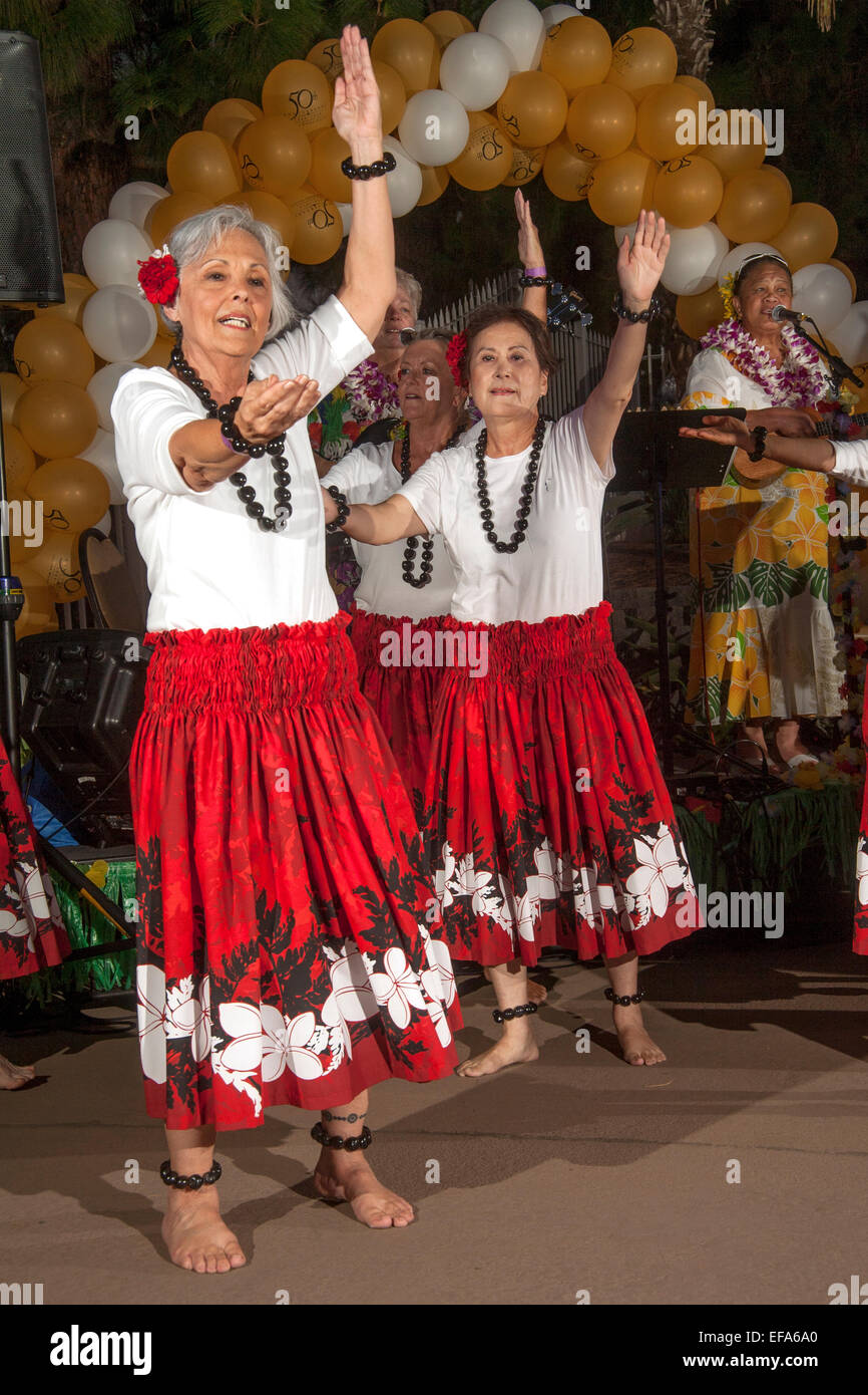 Les femmes âgées costumés à Laguna Woods, CA, la danse de la communauté de retraite à un thème hawaïen hula festival. Remarque musicien hawaiien en arrière-plan. Banque D'Images