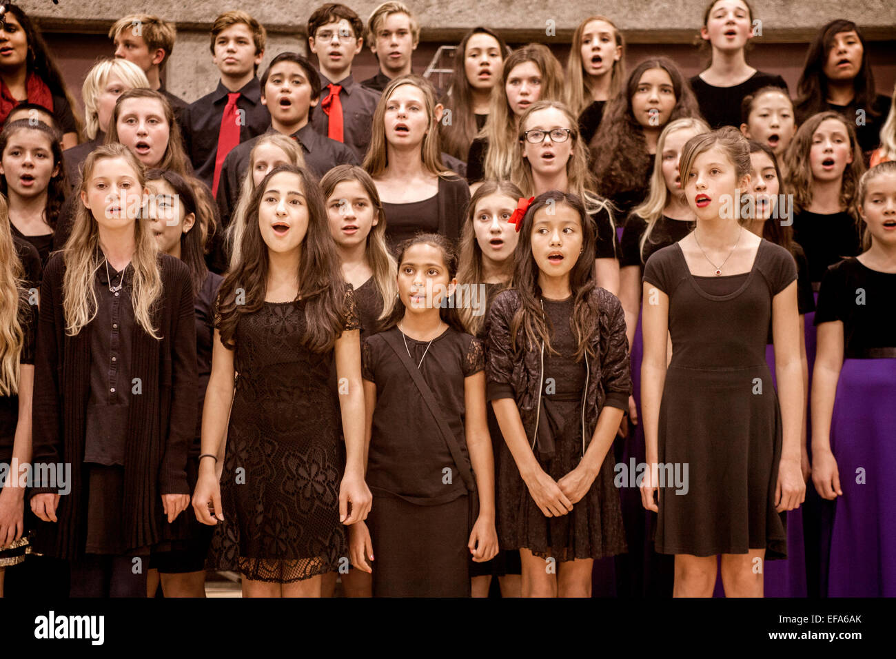 L'école intermédiaire multiraciale les enfants chantent des chants de Noël à la maison de concert qui se tiendra dans un Aliso Viejo, CA, de l'école secondaire d'un gymnase. Banque D'Images