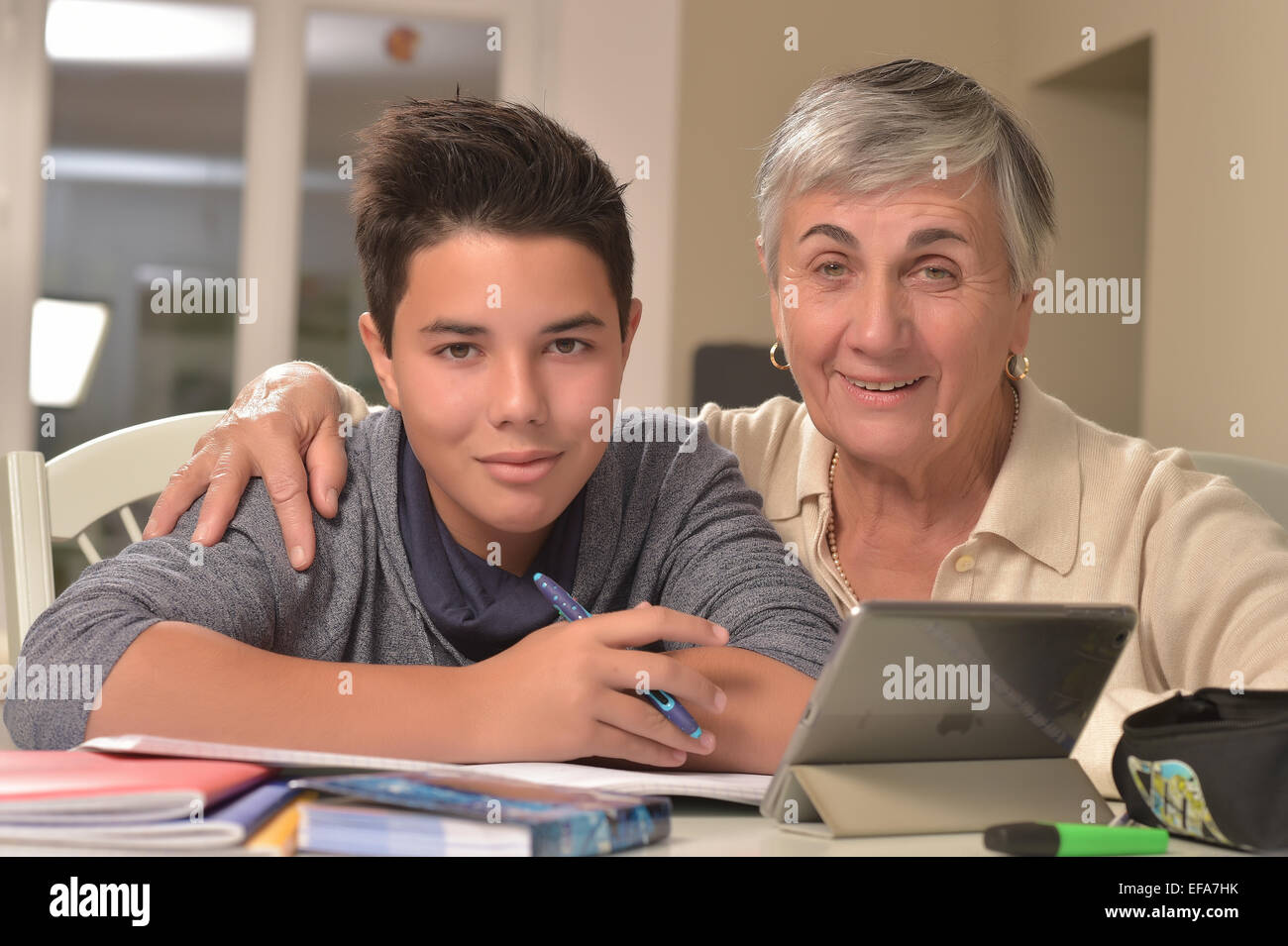 Petit garçon obtenir de l'aide pour les devoirs de sa grand-mère à la table Banque D'Images