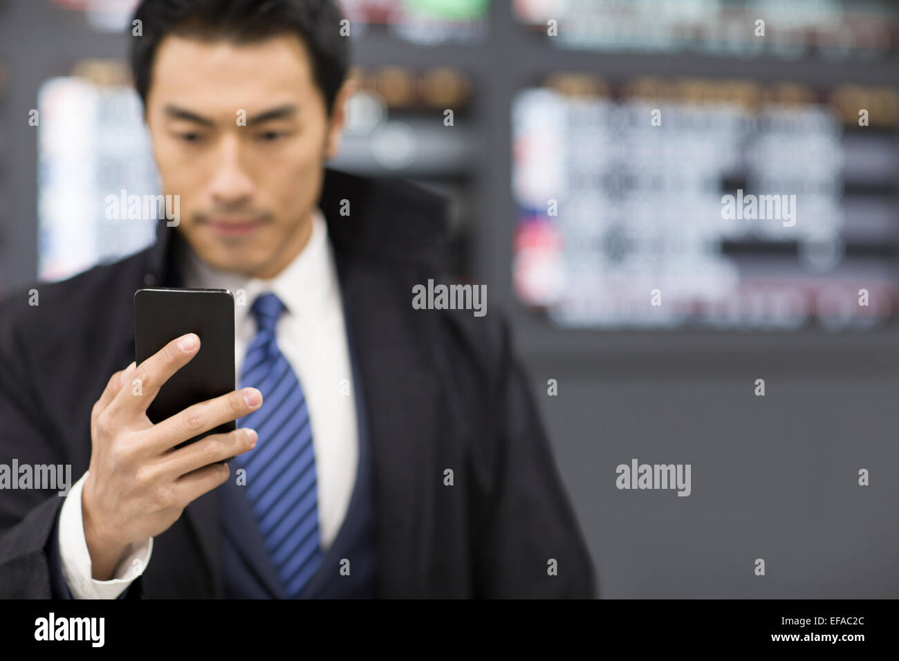 Young businessman using smart phone in airport Banque D'Images