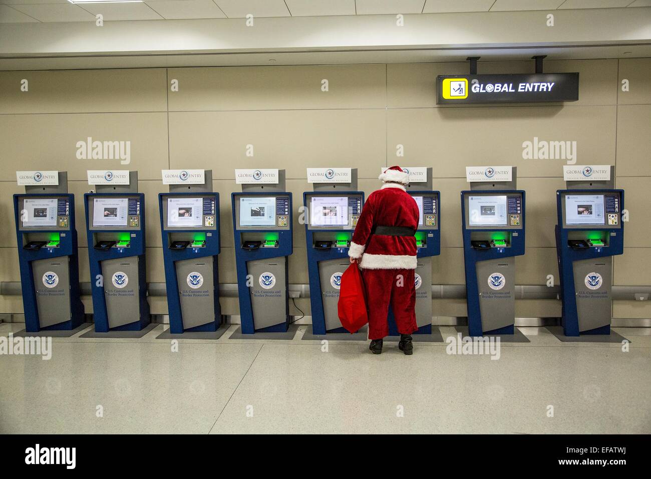 Le Père Noël utilise l'immigration américaine passe d'entrée Global machines automatisées puisqu'il s'apprête à effacer par le biais de l'immigration à la porte des arrivées internationales à l'aéroport de Dulles, le 8 décembre 2014 à Washington, DC. Banque D'Images