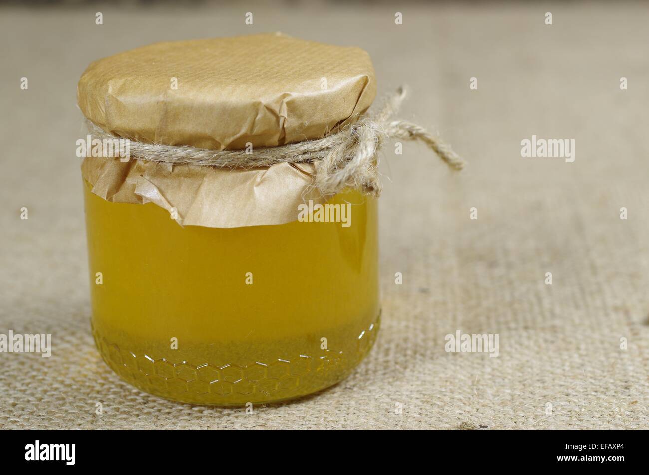 Pot de miel sur fond de jute Banque D'Images