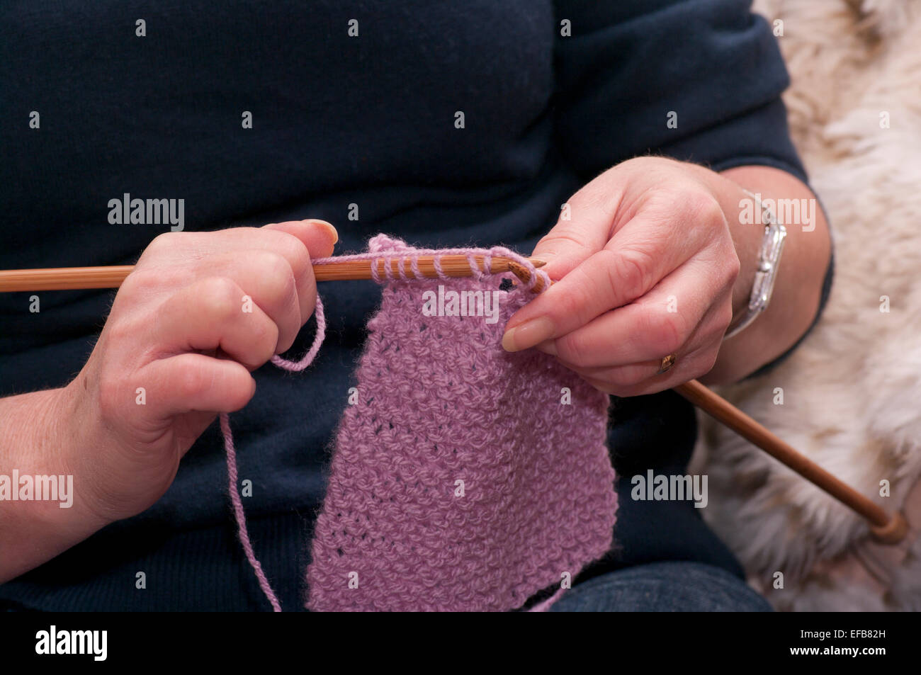 Les mains de womans tricot avec des aiguilles à tricoter et de la laine Banque D'Images
