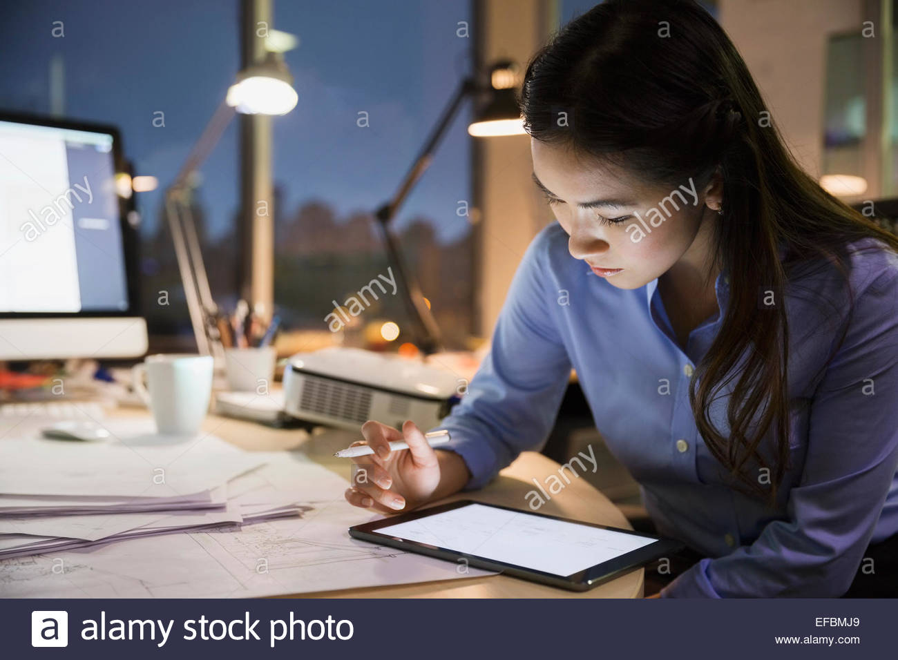 Businesswoman with digital tablet travailler tard dans office Banque D'Images