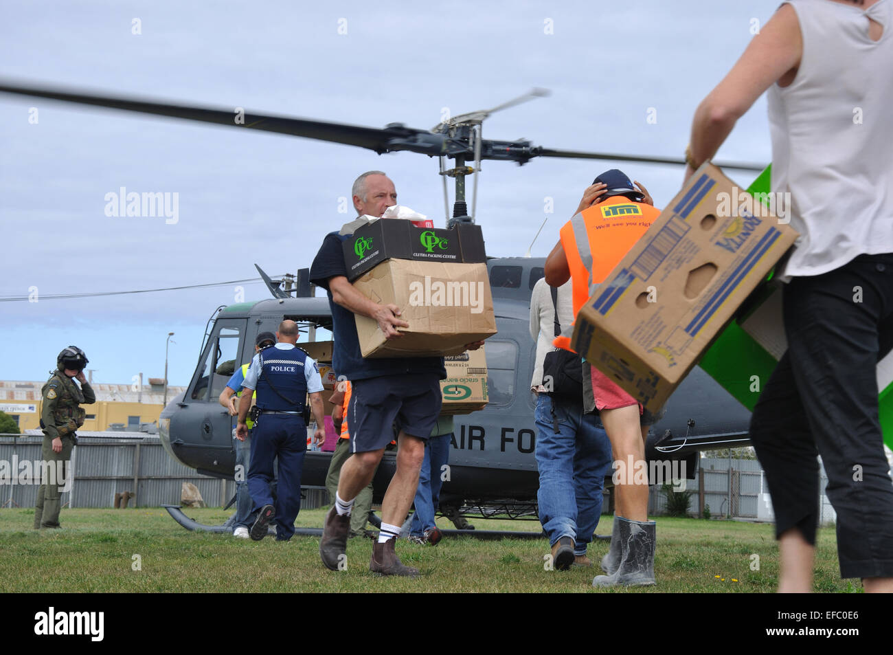 CHRISTCHURCH, Nouvelle-Zélande, le 22 février 2011 : le personnel de secours bénévoles ruée pour l'approvisionnement alimentaire à partir d'un hélicoptère de l'Armée de l'air Banque D'Images