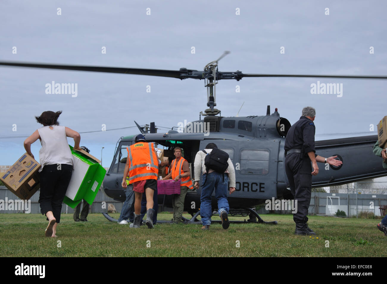 CHRISTCHURCH, Nouvelle-Zélande, le 22 février 2011 : le personnel de secours bénévoles ruée pour l'approvisionnement alimentaire à partir d'un hélicoptère de l'Armée de l'air Banque D'Images