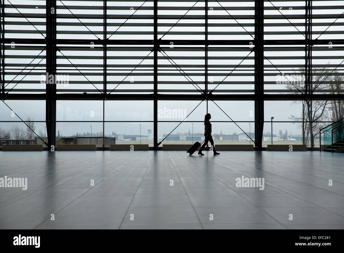 Woman walking in airport terminal Banque D'Images