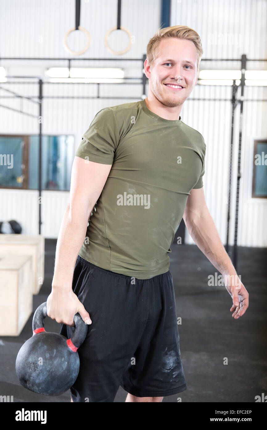 Homme bien formé avec kettlebell à fitness gym Banque D'Images