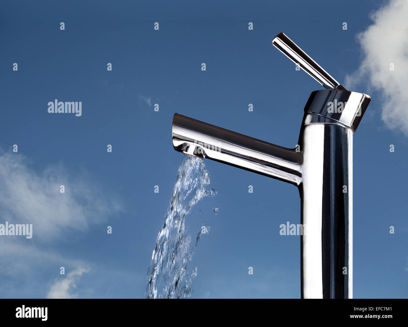 Un robinet avec de l'eau tournant, montré contre un ciel obscurci légèrement bleu indiquant la fraîcheur, la pureté, le gaspillage, etc. Banque D'Images