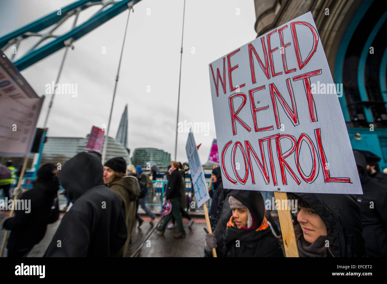 Londres, Royaume-Uni. Jan 31, 2015. Passant sur le Tower Bridge. Les gens ont marché depuis le sud de Londres et à l'Est de Londres à l'Hôtel de ville pour exiger l'amélioration des maisons pour les habitants de London et de mettre fin à la crise du logement. Ces revendications concernent le contrôle des loyers, abordables et sûres pour tous les foyers, un terme à la Chambre à coucher et du bien-être social de l'impôt des plafonds et la construction de nouveaux logements sociaux. L'événement a été appelé par la défense du logement et du Conseil de l'Assemblée populaire du sud de Londres. Et la route est de Londres a débuté à l'église paroissiale de Saint Leonard, Shoreditch, London, Royaume-Uni. 31 Jan 2015. Crédit : Guy Bell/Alamy Live News Banque D'Images