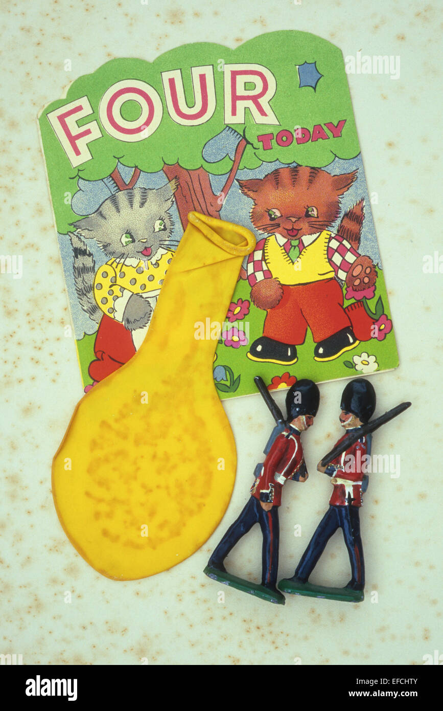 Vintage carte d'anniversaire avec des chats et indiquant quatre aujourd'hui couchant avec ballon jaune dégonflé et deux soldats modèle plomb Banque D'Images