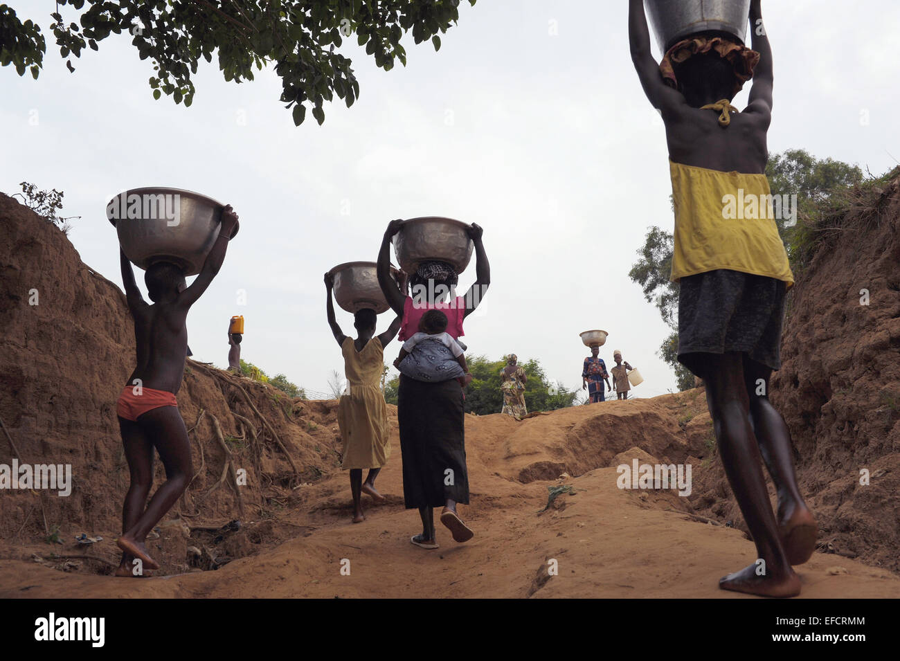 Les femmes et les enfants portant de l'eau du lac Volta, au Ghana. Banque D'Images
