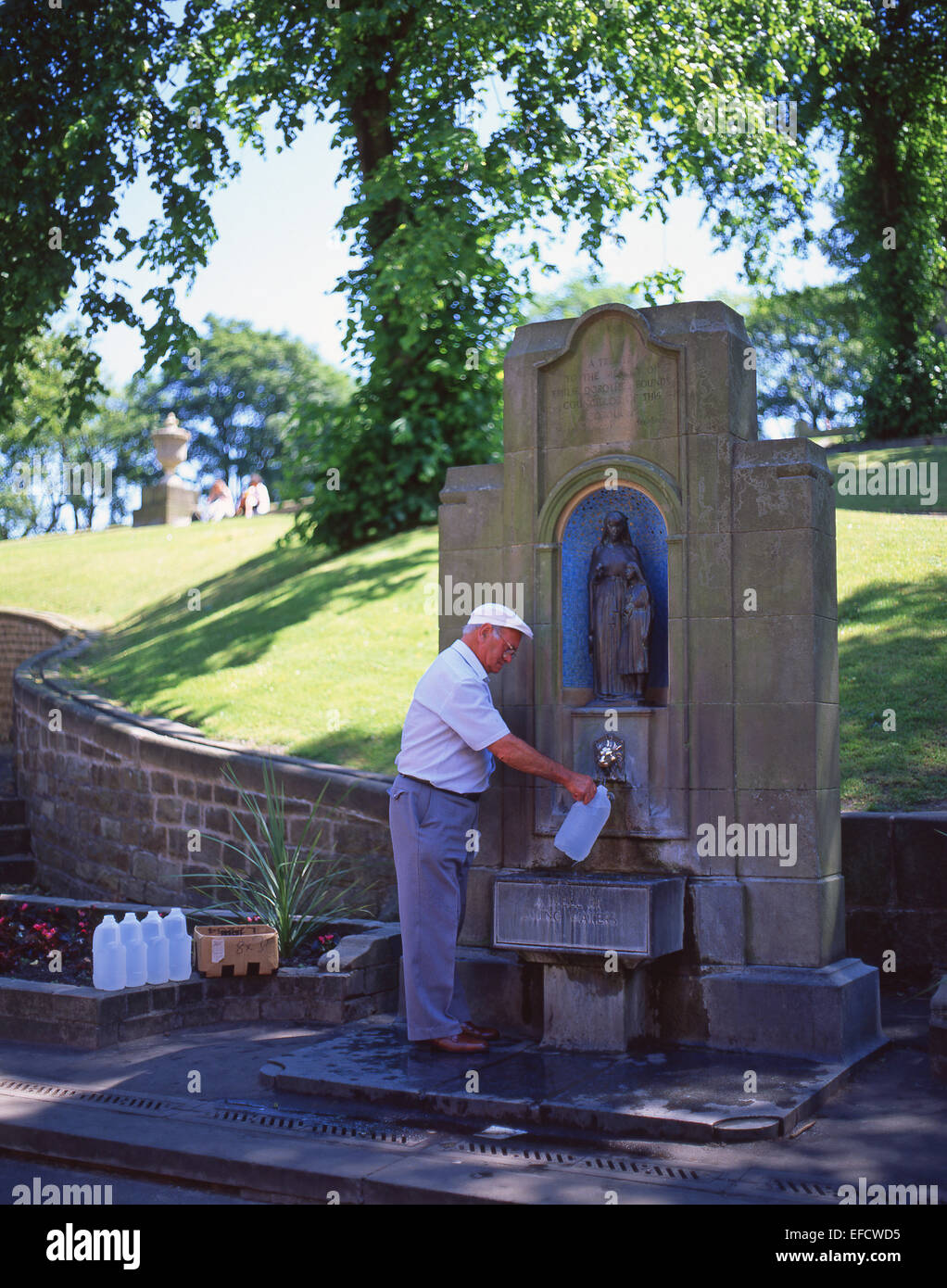 L'homme de remplir les bouteilles avec de l'eau à St Ann's Well, Buxton, Derbyshire, Angleterre, Royaume-Uni Banque D'Images