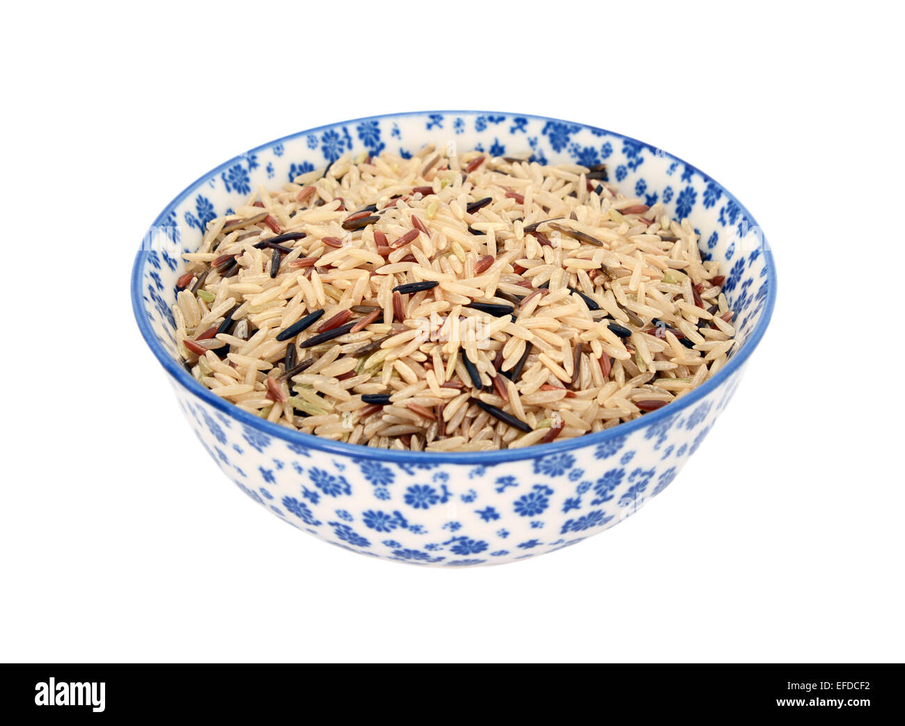 Le riz sauvage, le riz basmati brun et rouge grains camargue, dans un bol en porcelaine bleu et blanc avec un design floral Banque D'Images