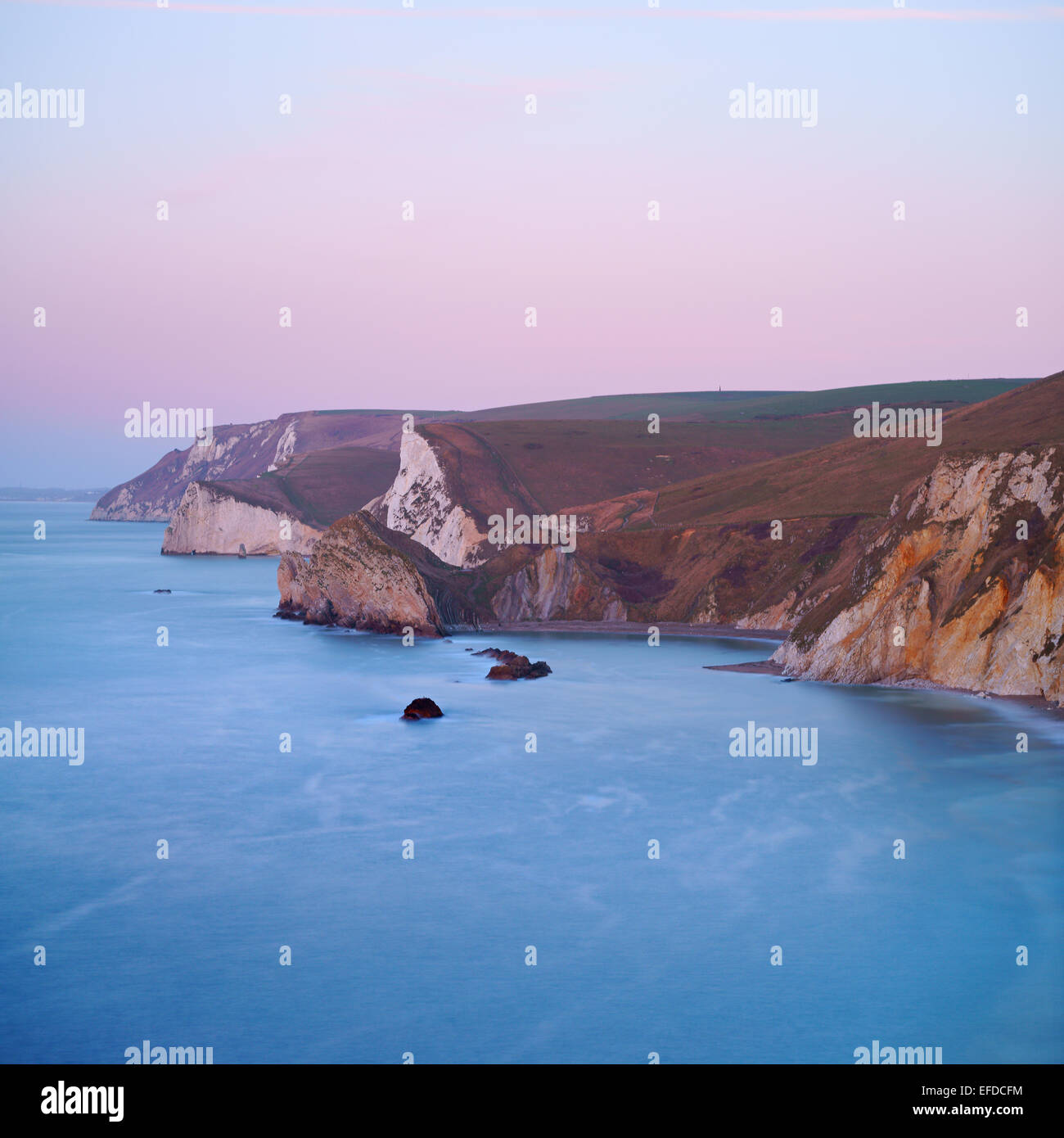 La Côte Jurassique autour de Durdle Dor au cours de l'hiver le lever du soleil. Roche tendre a été usé par la mer, formant une série de baies Banque D'Images