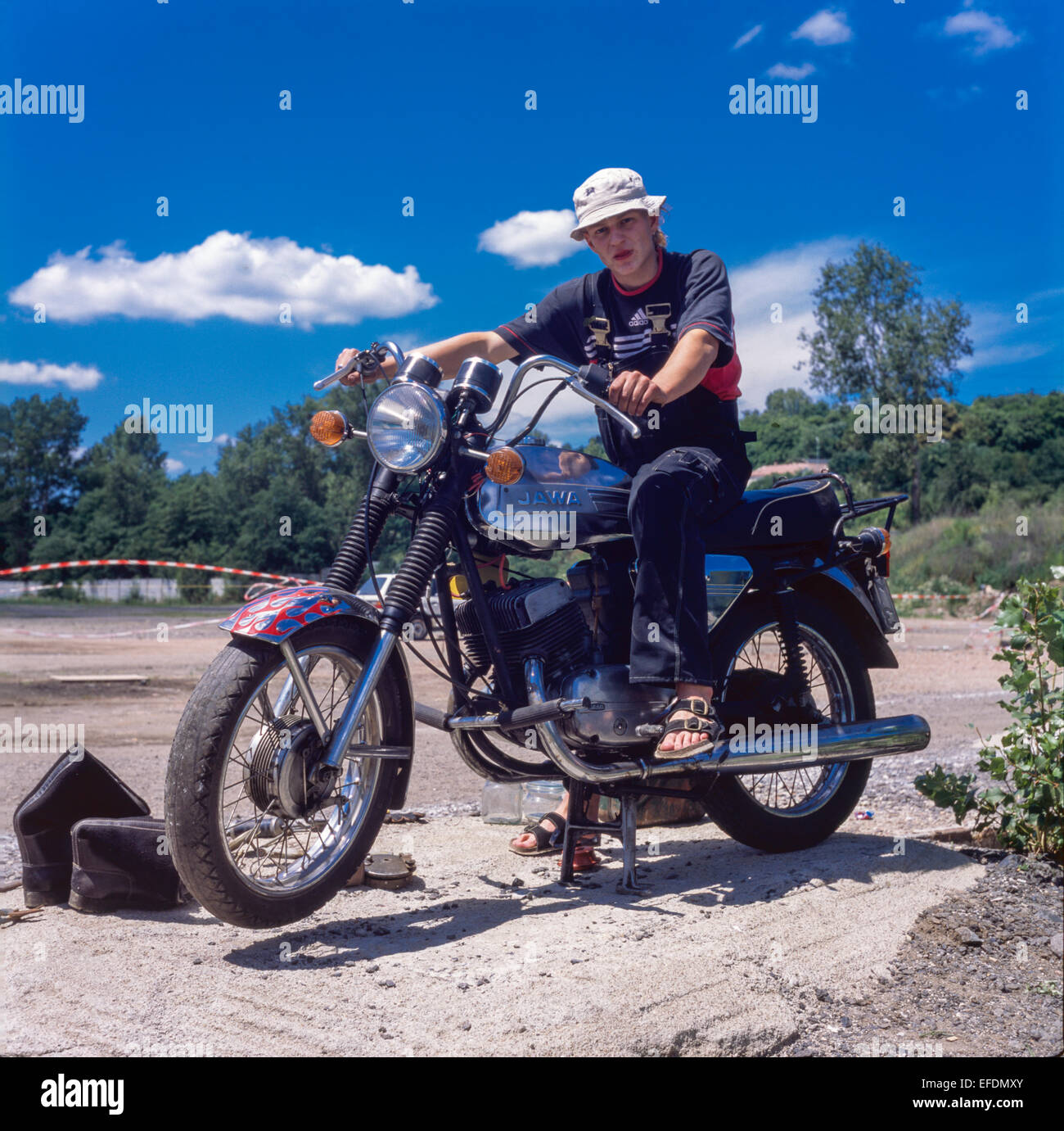 Jeune homme assis sur un vétéran de la marque de moto Jawa, République Tchèque Tchécoslovaquie des années 1970 Banque D'Images