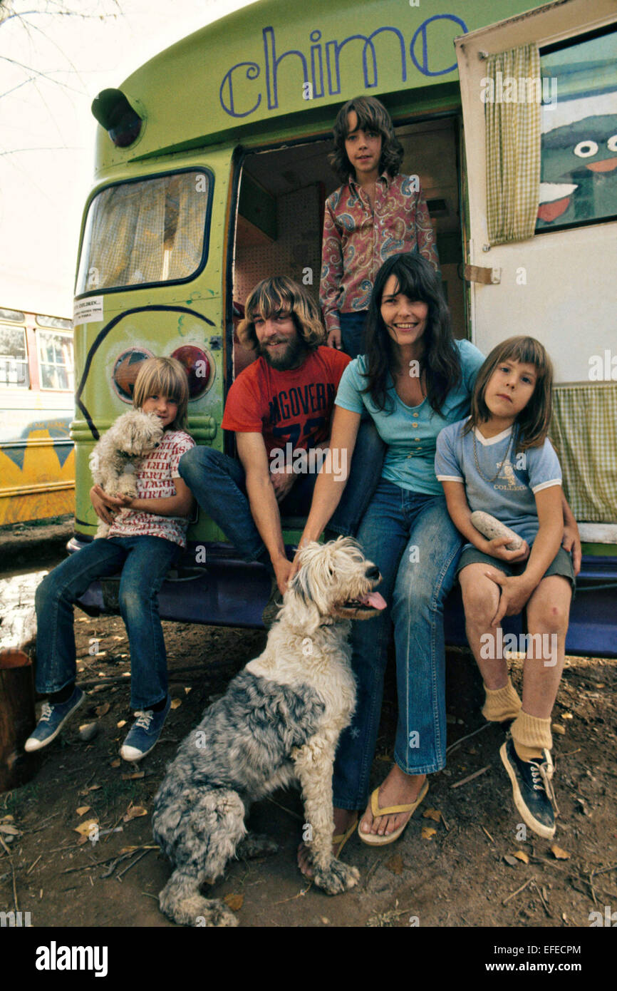 Une famille hippie pose par leur autobus scolaire qu'ils appellent