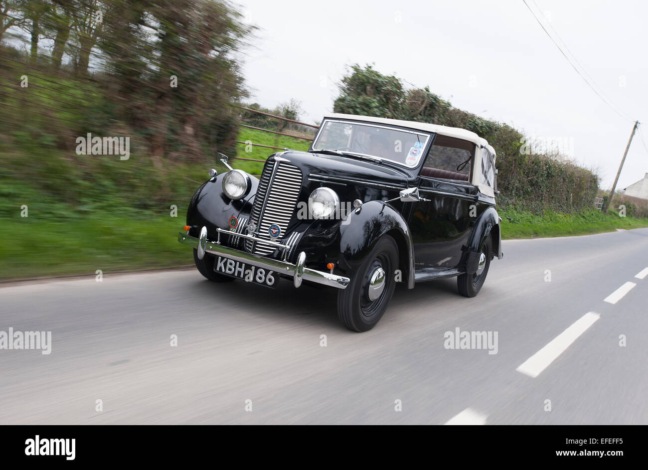 1939 Hillman Minx convertible roulant sur un chemin de campagne, la voiture familiale avant guerre Banque D'Images