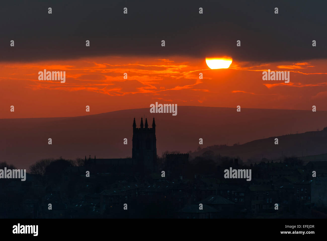 Un hiver chaud soleil se couche sur les collines de la Pennines du Sud silhouetting l'Église dans le village de Yorkshire près de Heptonstall Banque D'Images