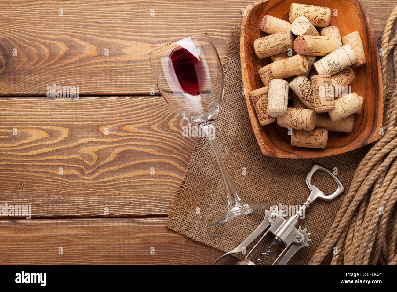 Verre à vin rouge, bouchons et tire-bouchon en bois sur fond de table with copy space Banque D'Images