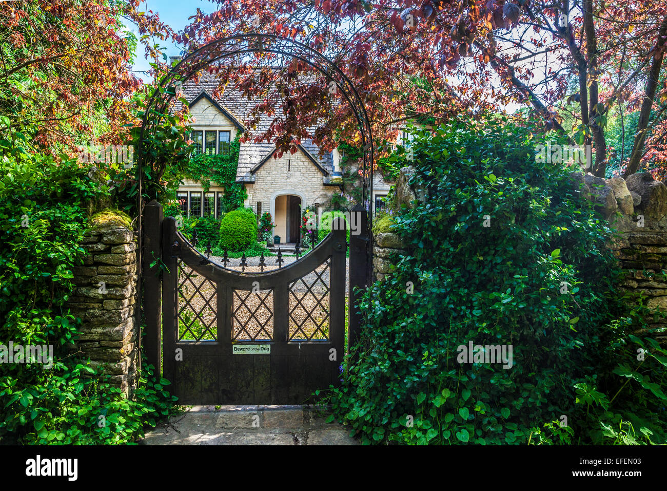 Vue à travers la porte du jardin d'une maison de campagne dans les Cotswolds dans le Wiltshire. Banque D'Images