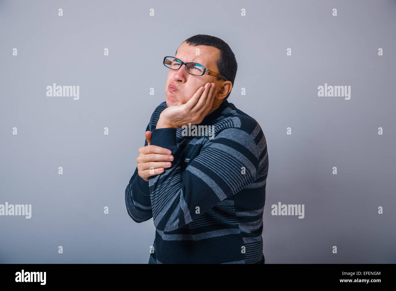 Homme d'une trentaine de brunet tenant ses mains o Banque D'Images