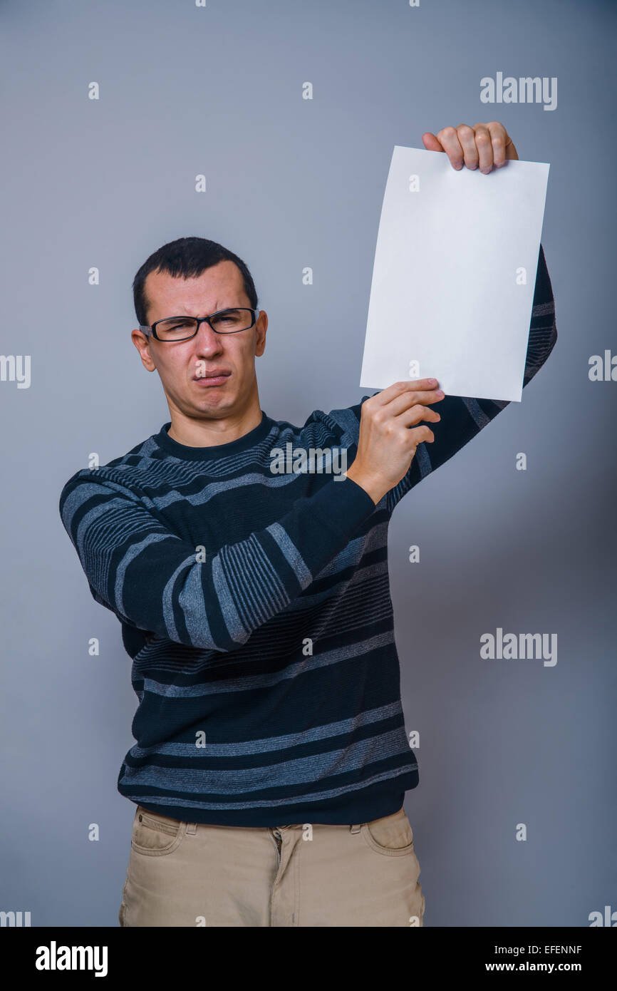 Homme à l'Européen de 30 ans tenant une feuille vierge, resentme Banque D'Images