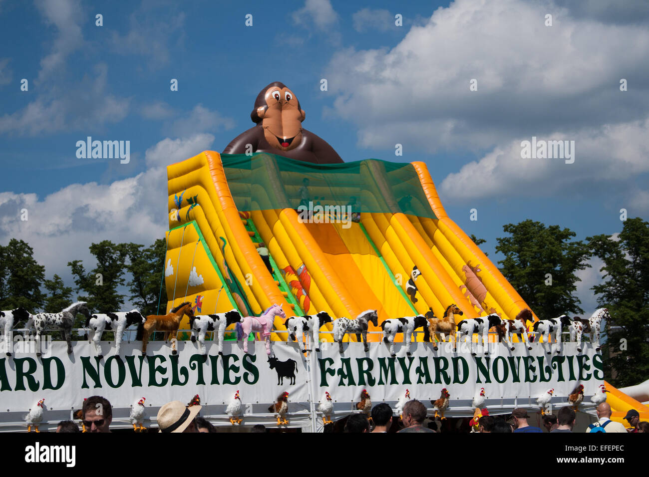 Toboggan gonflable géant avec un thème de singe à une foire amusante à côté d'un stand de nouveautés de ferme. Parkers Piece, Cambridge, Royaume-Uni Banque D'Images