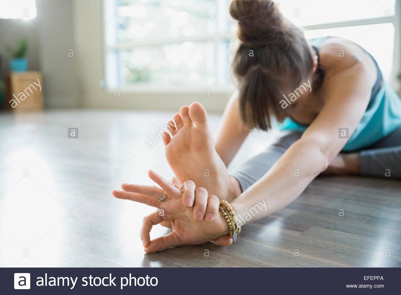 Femme en flexion avant assis pratiquer yoga mudra Banque D'Images
