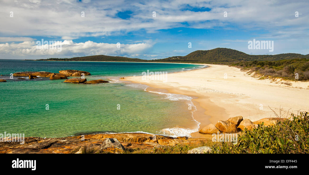 Vue panoramique de la plage de sable fin, eaux turquoise de l'océan Pacifique et la baie bordée par les dunes boisées au sud-ouest de Rocks NSW Australie Banque D'Images