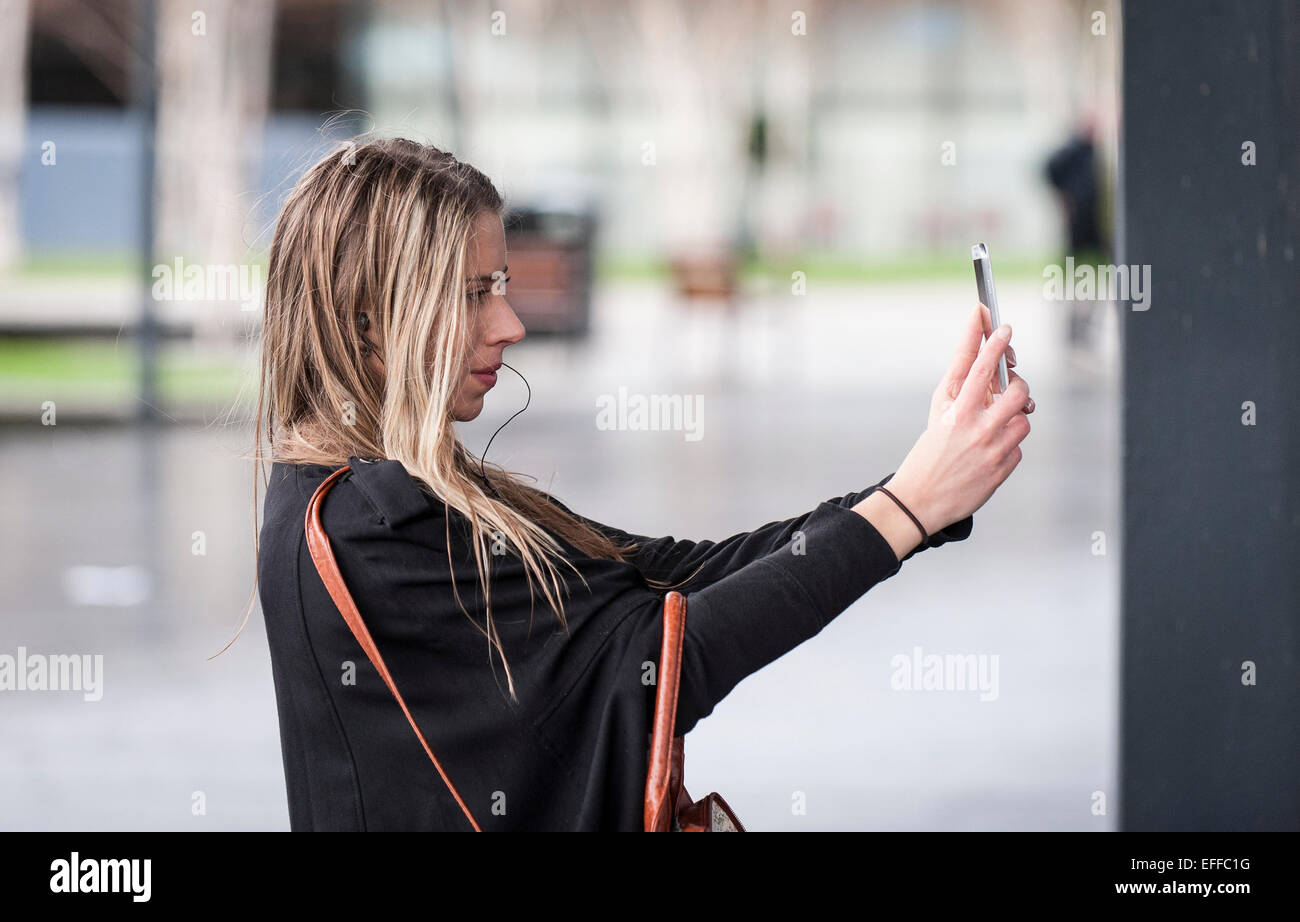 Une jeune femme tenant un téléphone mobile selfies avec elle. Banque D'Images