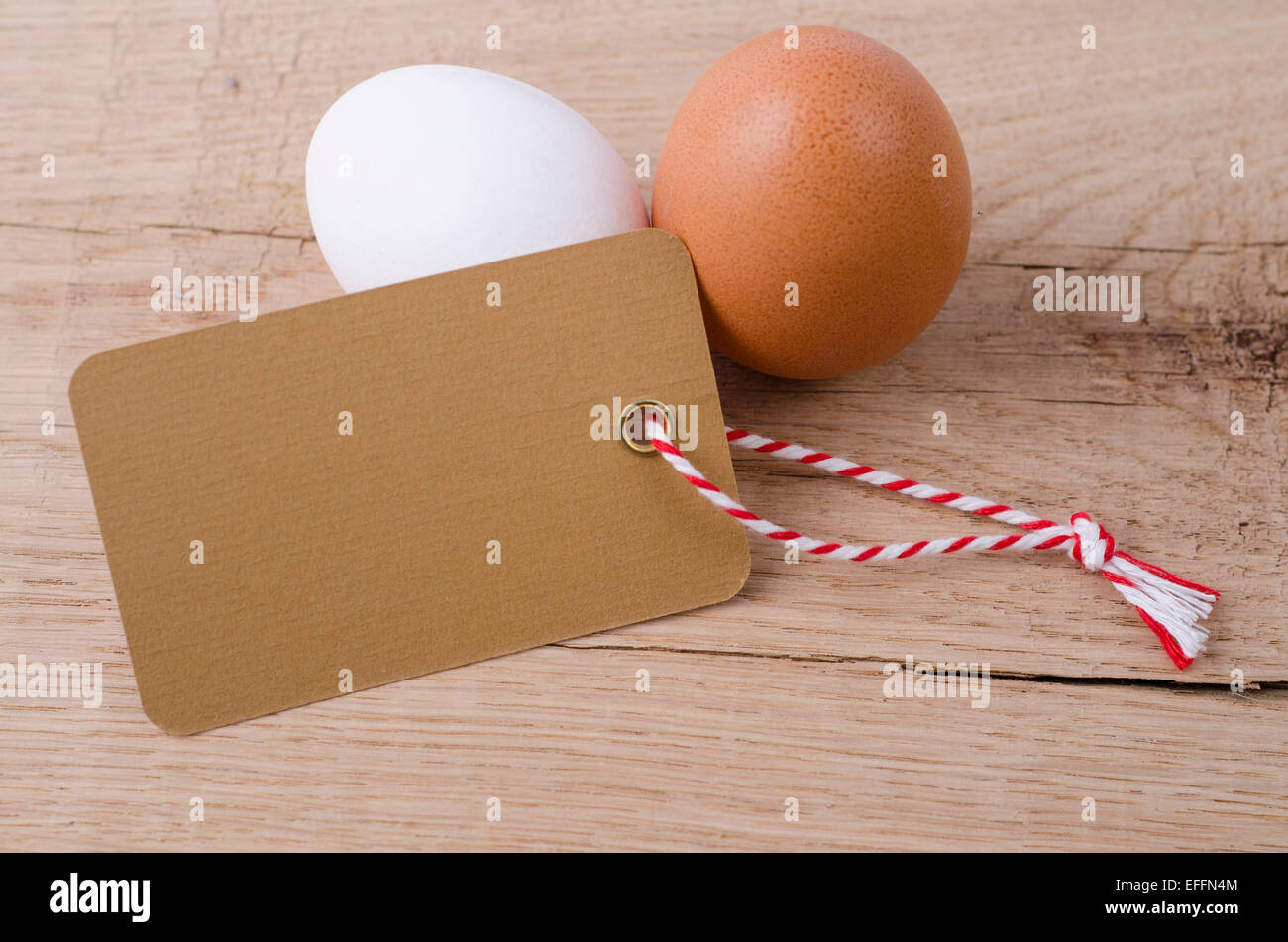 Brown egg, l'œuf blanc et étiquette vierge sur bois Banque D'Images