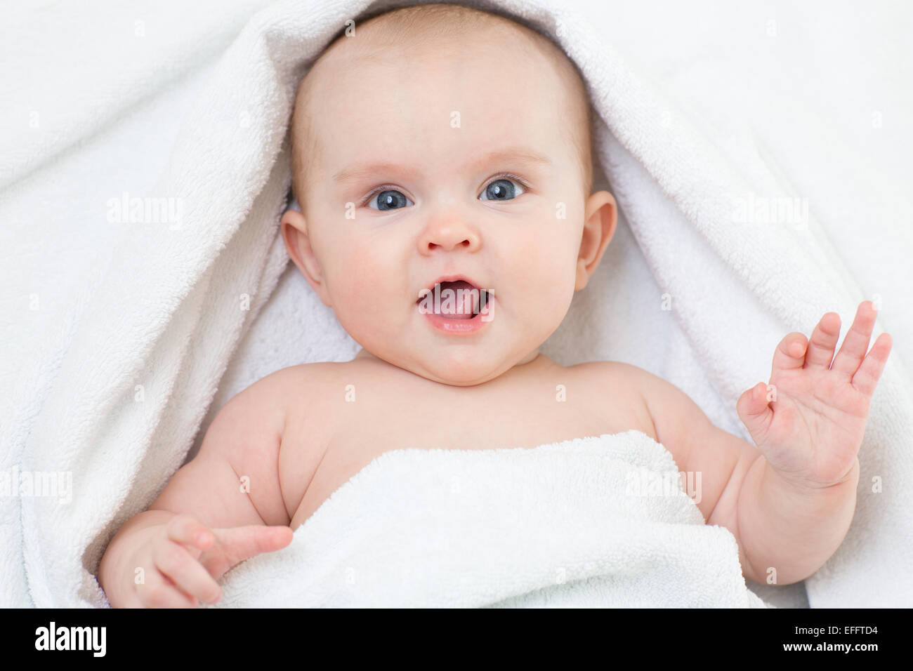 Cute smiling baby portrait couché sur une serviette de bain Banque D'Images
