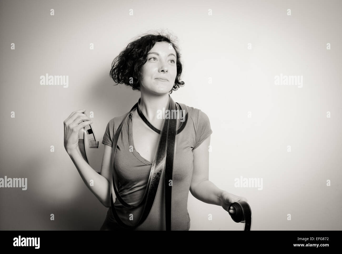 Jolie jeune femme avec collier et rêvant de film comme expression en noir et blanc vintage Banque D'Images