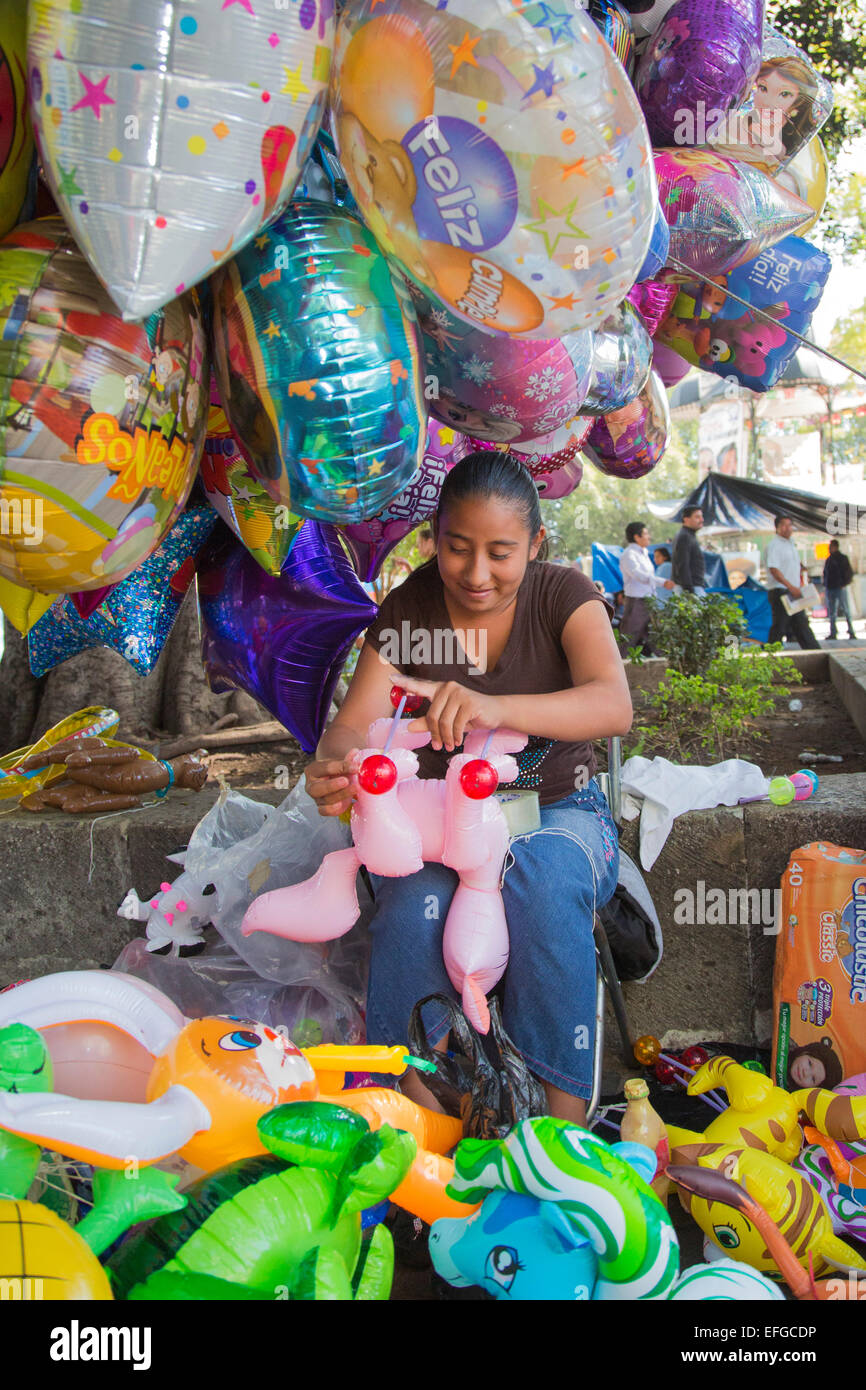 Oaxaca, Mexique - une femme fabrique et vend des jouets de ballons à le Zócalo (place centrale). Banque D'Images