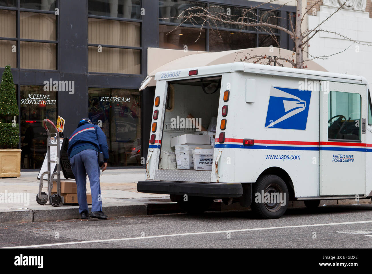Mailman nous travailler derrière des camions de livraison - USA Banque D'Images