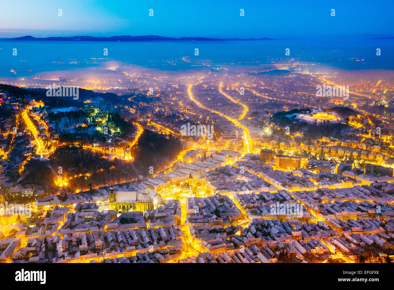 Nuit paysage d'hiver de la ville médiévale de Brasov, la Transylvanie en Roumanie avec place du Conseil, de l'église noire et de la Citadelle Banque D'Images