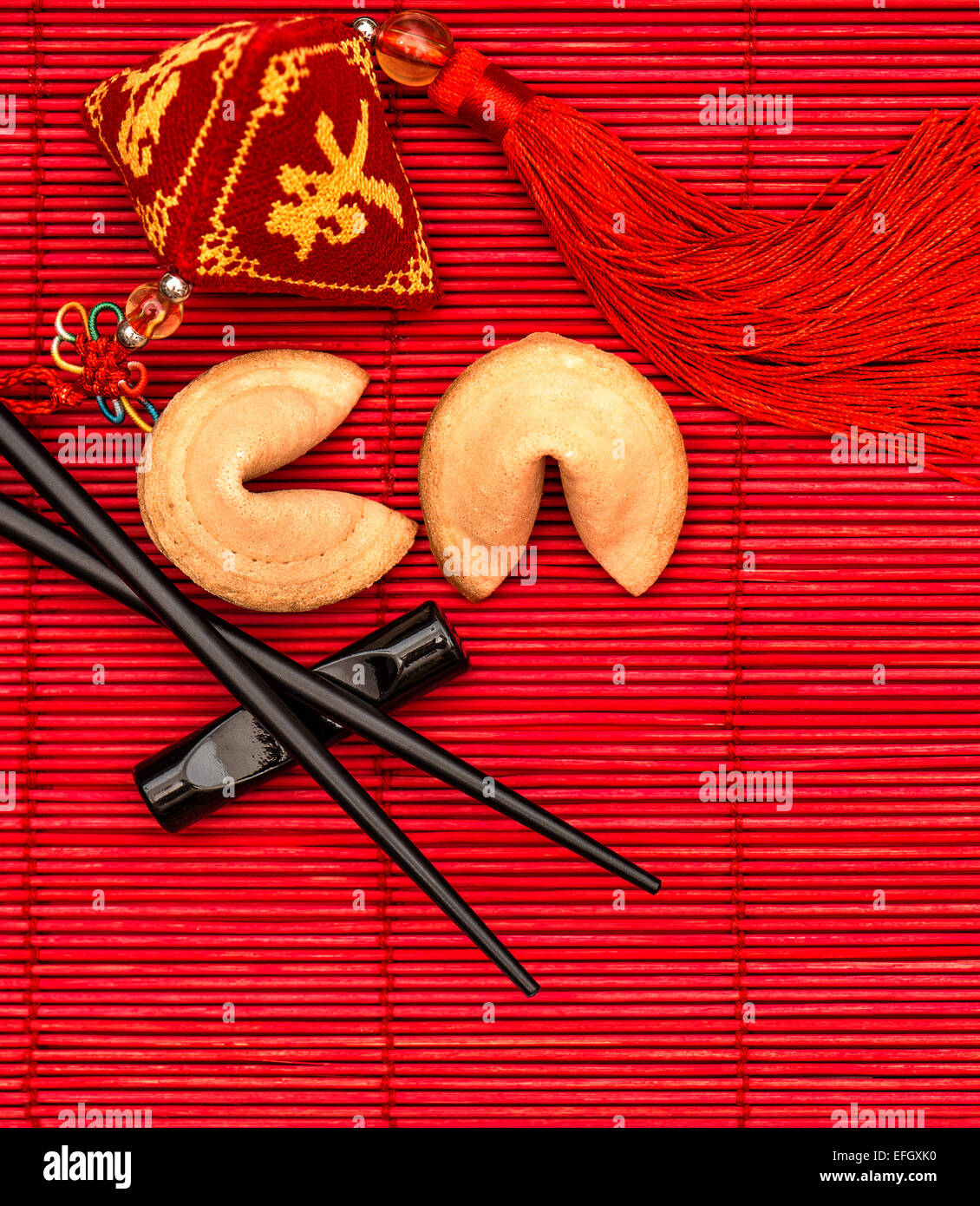 Porte-bonheur, fortune cookies et baguettes. Le nouvel an chinois fond rouge Banque D'Images