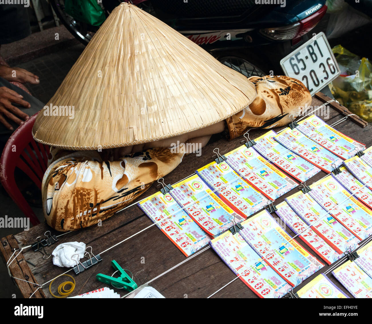 Une Vietnamienne vente de billets de loterie dans une rue à Can Tho. Banque D'Images