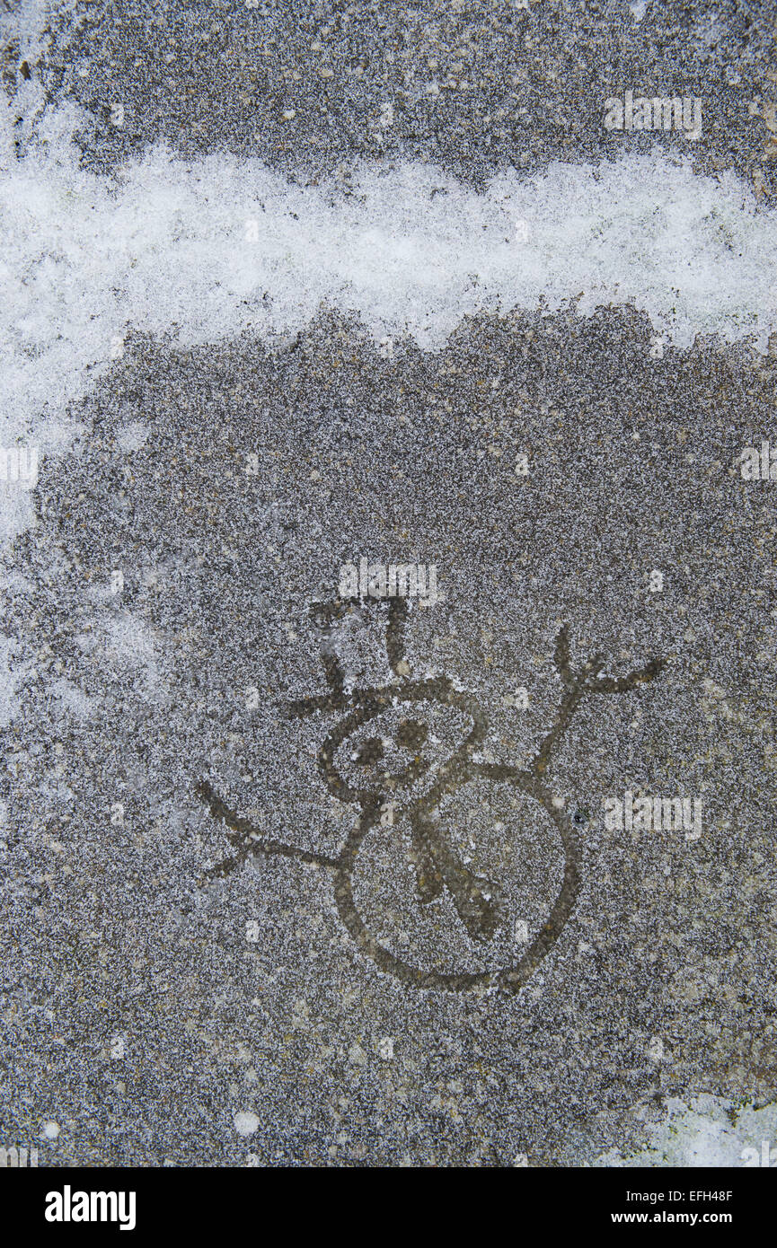 Snowman frosty dessiné sur un chemin de jardin Banque D'Images
