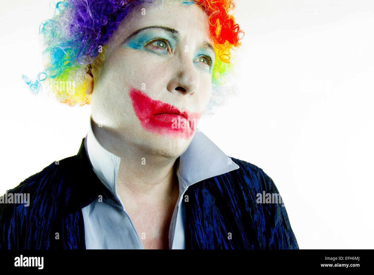Femme vêtue de clown perruque et maquillage avec une expression triste dans ton haut Banque D'Images