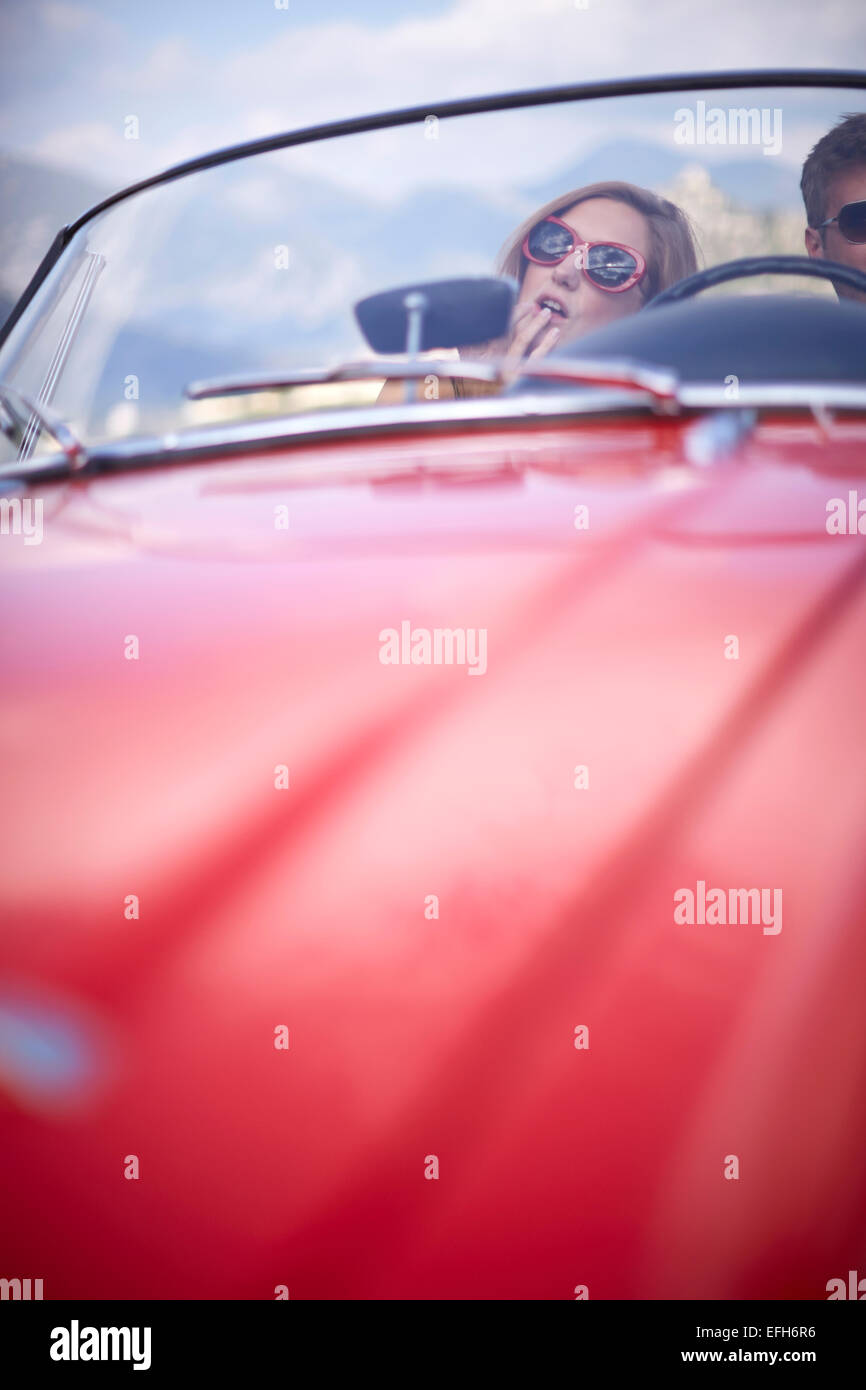 Young couple having fun in dans un cabriolet voiture sport rouge dans le sud de la France Banque D'Images