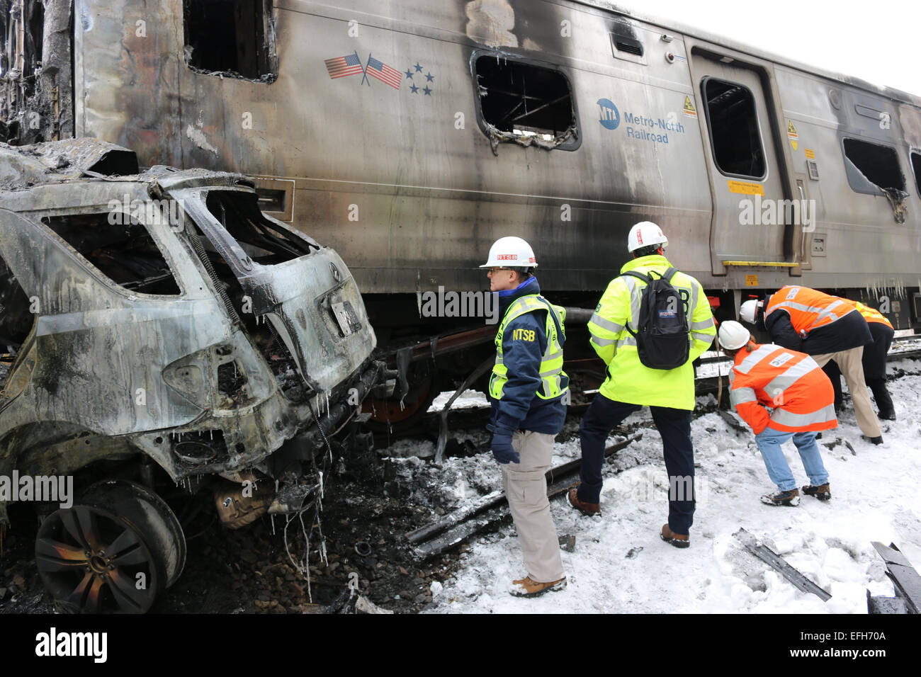 Un enquêteur sur les accidents du NTSB Robert Sumwalt vues l'épave calcinée d'un Metro North Train voiture qui a heurté un VUS tuant six personnes et en blessant 12 autres blessés le 4 février 2015 à New York, le comté de Westchester. Banque D'Images