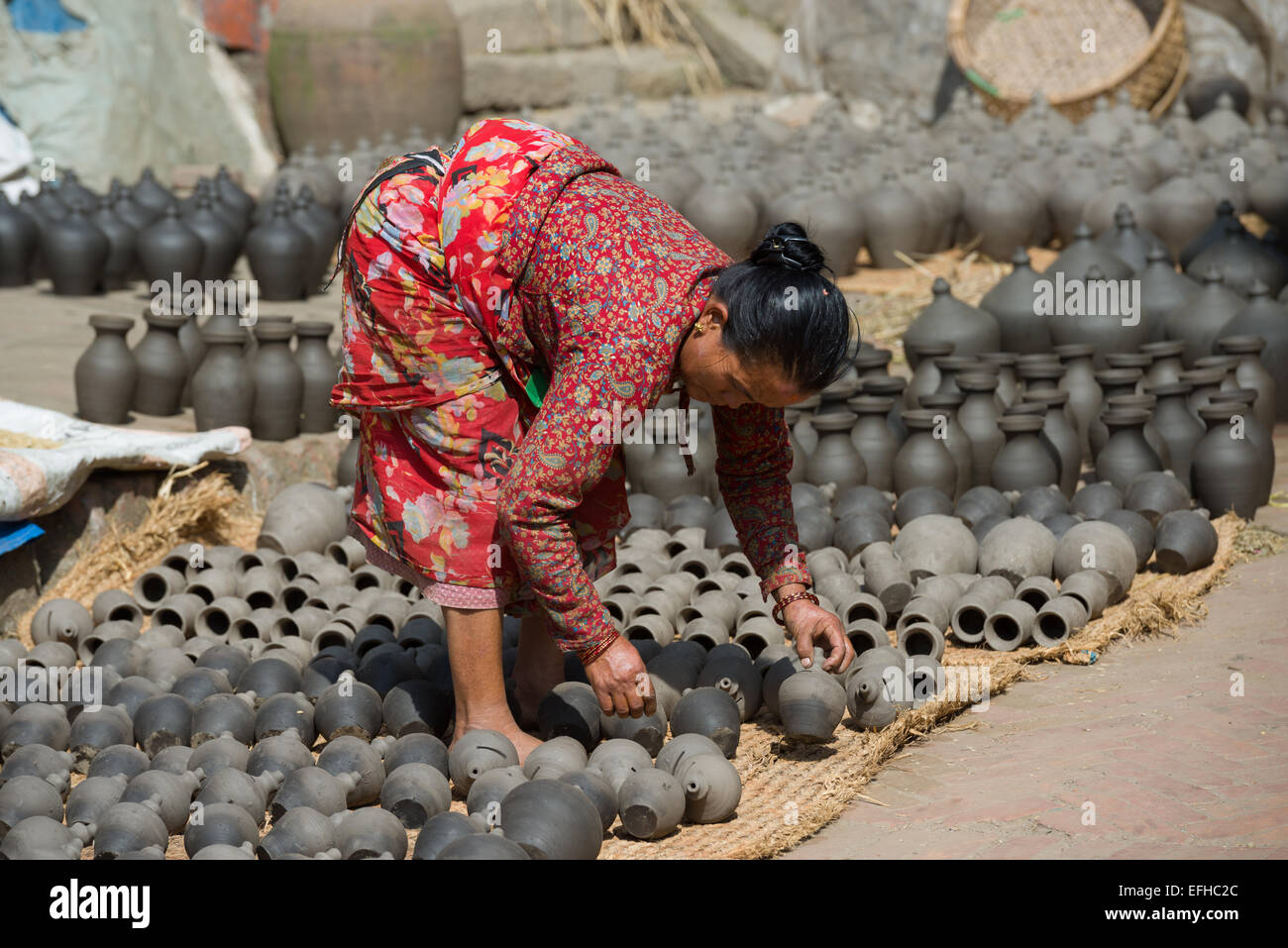 Femme tournant des pots de séchage dans le potter's Square, Bhaktapur, Vallée de Katmandou, Népal Banque D'Images