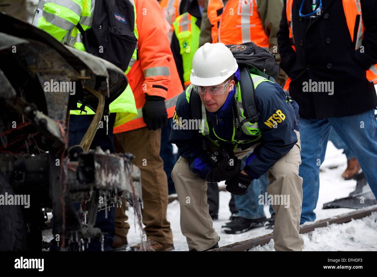 Les enquêteurs du NTSB voir l'épave calcinée d'un Metro North Train voiture qui a heurté un VUS tuant six personnes et en blessant 12 autres blessés le 4 février 2015 à New York, le comté de Westchester. Banque D'Images