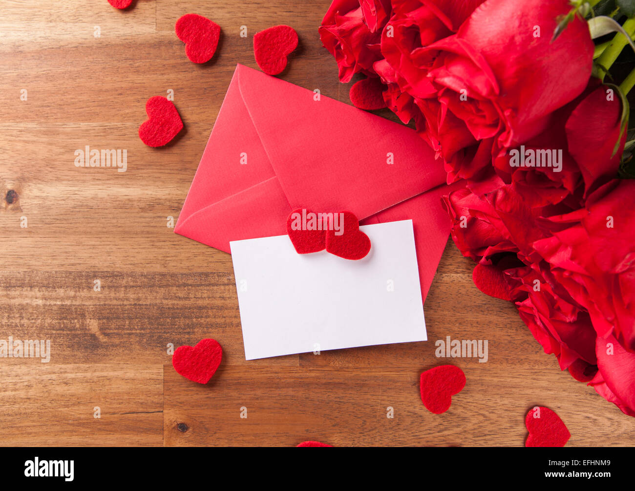 Bouquet de roses avec des enveloppes et cartes de voeux vierges sur un bureau en bois Banque D'Images