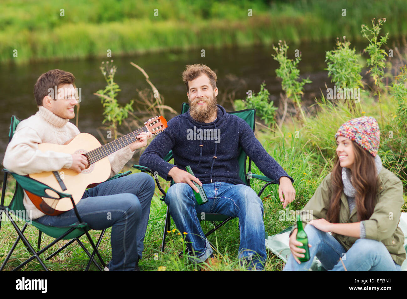 Groupe de touristes à jouer de la guitare dans camping Banque D'Images