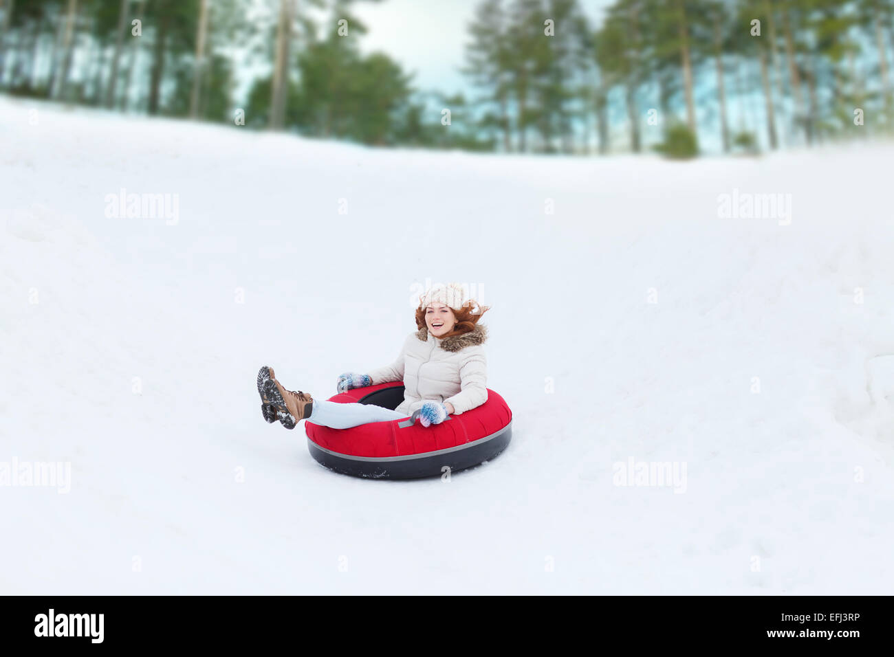 Teenage girl glissant le long du tube sur la neige Banque D'Images