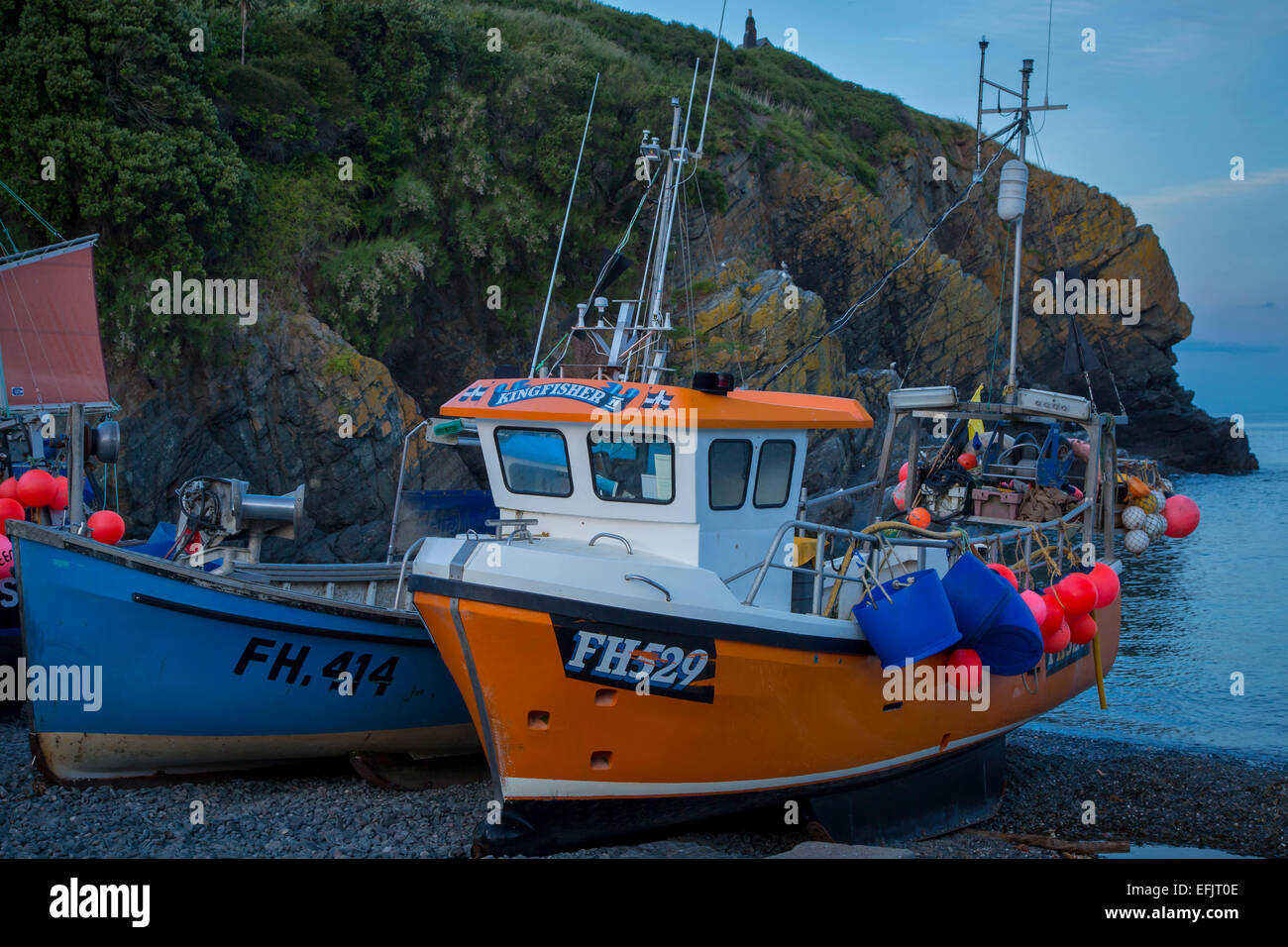 Bateaux de pêche échoués à marée basse le soir à Cadgwith Cove, Cornwall, England, UK Banque D'Images