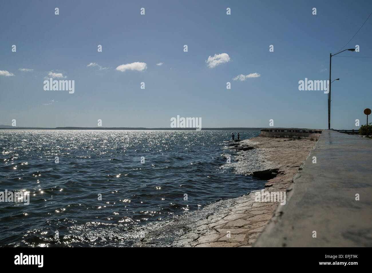 Silhouetté Cubains pêchent dans les eaux claires de la baie de Cienfuegos à partir de la détérioration de la paroi de la mer dans la zone de Punta Gorda Cienfuegos, Cuba. Banque D'Images